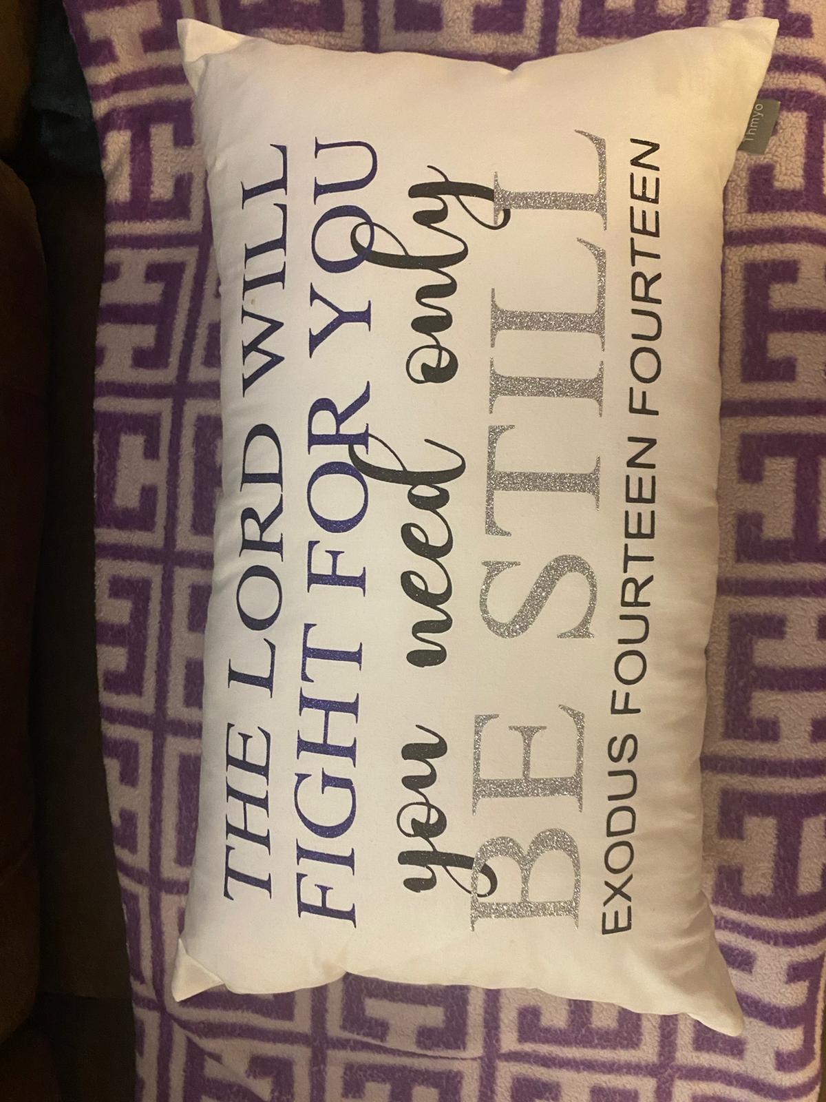 Decorative pillow with inspirational text on a patterned background